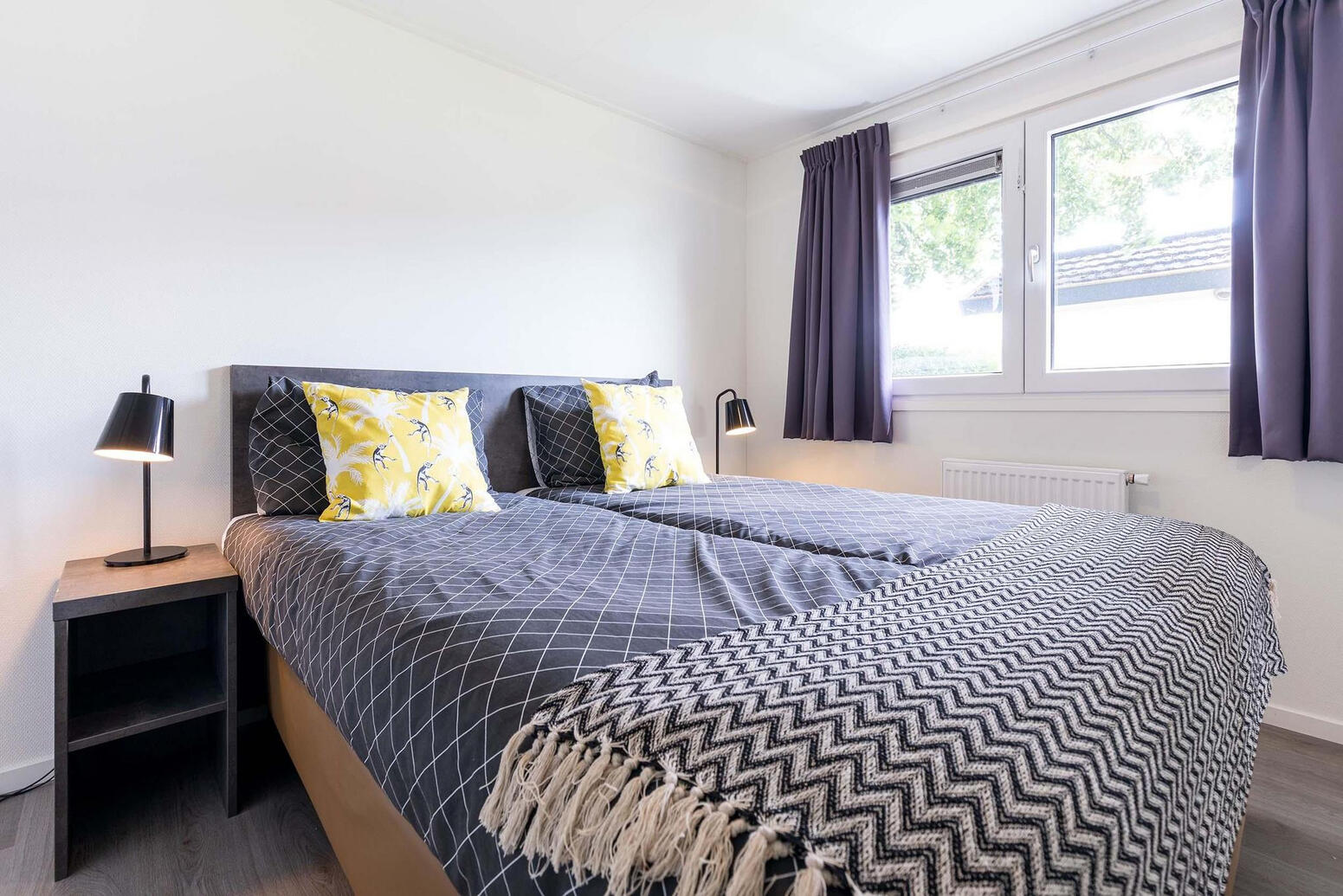 tweepersoonbed met veel ruimte en lampen aan beide zijden